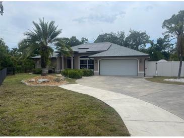 Charming single-story home with a well-manicured lawn and inviting curb appeal, plus a circular driveway at 652 N Elm St, Englewood, FL 34223