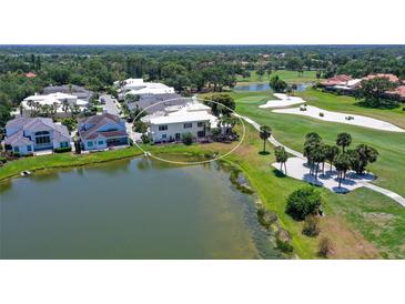 An aerial view of a waterfront home situated on a golf course with beautiful landscaping and outdoor patio at 7728 Club Ln, Sarasota, FL 34238