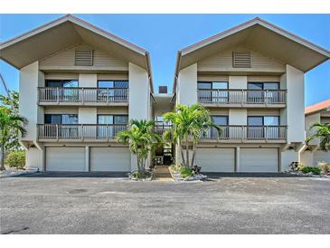 A well maintained condominium exterior shows covered parking and balconies with tropical plants adding to the landscape at 1159 Lake House Cir # C120, Sarasota, FL 34242
