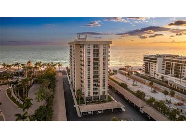 Stunning beachfront high-rise condo with private parking, manicured landscaping, and beautiful ocean views at sunset at 1212 Benjamin Franklin Dr # 909, Sarasota, FL 34236