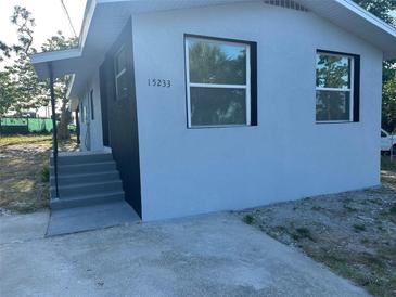 Exterior of updated home featuring a freshly painted exterior, new windows and manicured front yard at 15233 Omaha St, Hudson, FL 34667