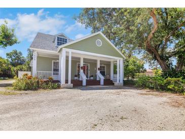 Inviting two-story home with a charming front porch and beautifully landscaped with ample parking at 1526 Ewing St, Nokomis, FL 34275