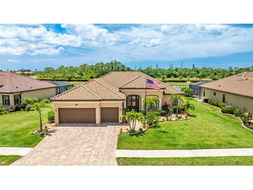 Stunning single-story home with a tile roof, three-car garage, and a lush, manicured lawn at 20359 Cristoforo Pl, Venice, FL 34293