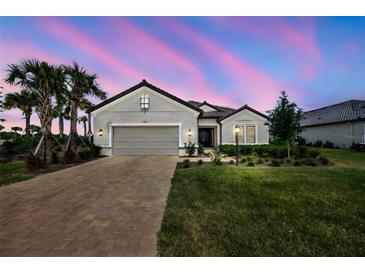 Beautiful one-story home featuring a well-manicured lawn, brick driveway, and a two-car garage at 3679 Santa Caterina Blvd, Bradenton, FL 34211
