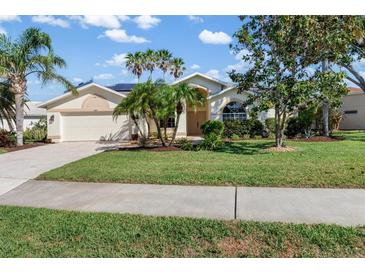 Inviting single-story home featuring a well-manicured lawn and tropical palm trees at 4063 Westbourne Cir, Sarasota, FL 34238