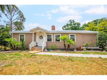 Charming home featuring a well-manicured lawn, cozy front porch, and colorful landscaping at 4922 18Th E St, Bradenton, FL 34203