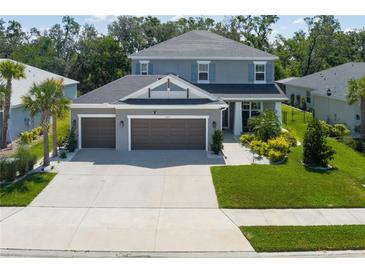 Beautiful two-story home showcasing a three-car garage and a well-manicured lawn at 6017 Maidenstone Way, Palmetto, FL 34221