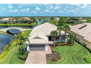 Stunning waterfront home featuring a tile roof, well-manicured lawn and mature palm trees at 13167 Fernando St, Venice, FL 34293