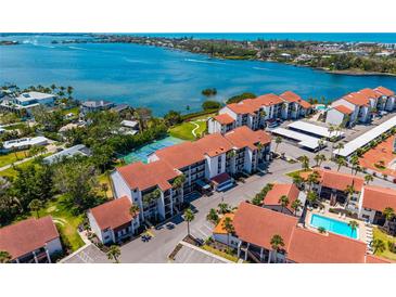 Stunning aerial view of waterfront condos featuring lush landscaping, a pool, and gorgeous water views at 1624 Stickney Point Rd # 204, Sarasota, FL 34231