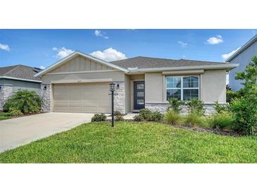 Charming one-story home featuring a stone-accented facade and a well-manicured lawn with lush landscaping at 17119 Barnwood Pl, Bradenton, FL 34211