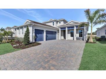 Charming home featuring a manicured lawn, lush plantings, and a spacious driveway leading to a two-car garage at 17927 Palmiste Dr, Bradenton, FL 34202
