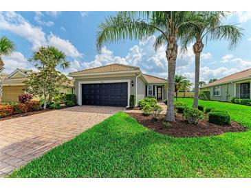 Charming single-story home featuring a brick driveway, lush landscaping, and well-maintained lawn at 19038 Lappacio St, Venice, FL 34293
