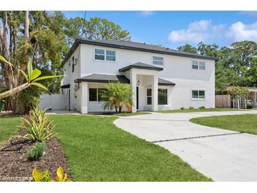 Two-story home with a white exterior, black trim, well-manicured lawn and inviting curb appeal at 2655 Bay St, Sarasota, FL 34237