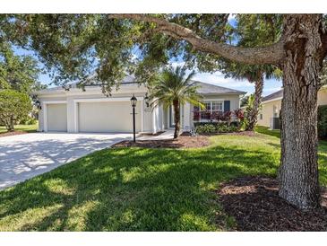 Charming single-story home with a well-manicured lawn and a three-car garage, enhanced by mature trees and landscaping at 4712 Charles Partin Dr, Parrish, FL 34219