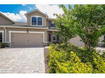 Charming two-story home showcasing a well-manicured lawn and a paved driveway leading to a two-car garage at 5237 Blossom Cv, Lakewood Ranch, FL 34211