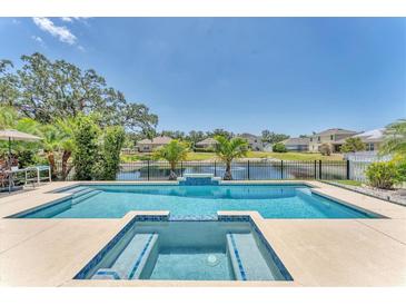 Sparkling pool and spa overlooking the serene lake at 5717 71St E St, Palmetto, FL 34221