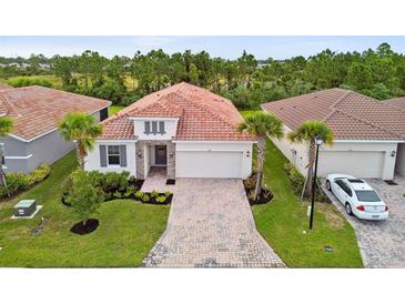 An aerial view of a charming single-story home with a terracotta tile roof and manicured landscaping at 620 Nasturtium Ct, Nokomis, FL 34275