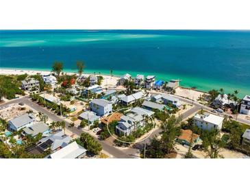 Beautiful aerial view of beachfront property with lush landscaping and turquoise water at 802 N Bay Blvd, Anna Maria, FL 34216