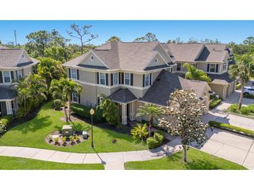 Beautifully landscaped home with a manicured lawn, palm trees, and lush plantings at 8073 Tybee Ct, University Park, FL 34201