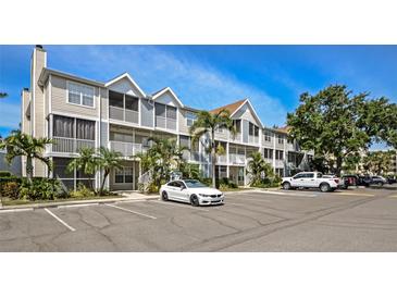 Attractive condo building with well-manicured landscaping and ample parking on a sunny day at 850 S Tamiami Trl # 431, Sarasota, FL 34236