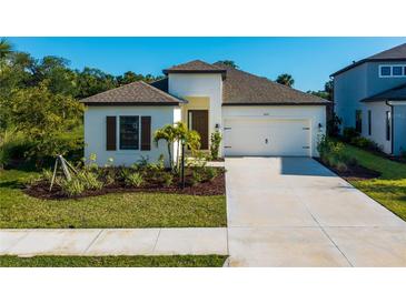 Charming one-story home featuring a well-manicured lawn and a two-car garage with lovely landscaping at 10171 Milky Way Cir, Sarasota, FL 34241