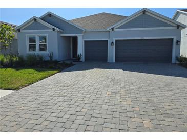 Charming single-story home featuring a paved driveway and a two-car garage at 1591 Laurel Brook Ln, Port Charlotte, FL 33953
