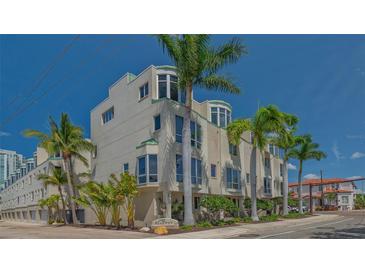 Stunning condo building featuring multiple floors and a corner facade, surrounded by lush palm trees at 235 Cocoanut Ave # 108B, Sarasota, FL 34236