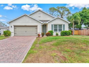 Charming single-story home with a well-manicured lawn and a brick-paved driveway at 3924 Candia Ave, North Port, FL 34286