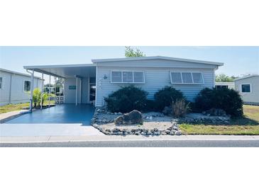 Charming single-story home featuring a covered parking area, lovely landscaping, and a welcoming facade at 415 Oakwood Blvd, Sarasota, FL 34237