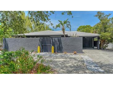 Contemporary home featuring a textured gray exterior, white tile roof, and stylish yellow decor at 4857 Stevens Dr, Sarasota, FL 34234