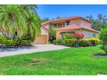 Charming two-story home featuring a tile roof, attached garage and vibrant landscaping at 7551 Calle Facil, Sarasota, FL 34238