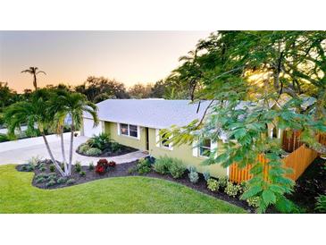 Charming single-story home with a well-manicured lawn and mature tropical landscaping at 1010 68Th Nw St, Bradenton, FL 34209