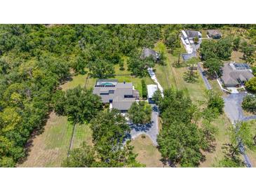 Aerial view of a private estate featuring a pool, long driveway, and mature trees at 140 Cowpen Ln, Sarasota, FL 34240