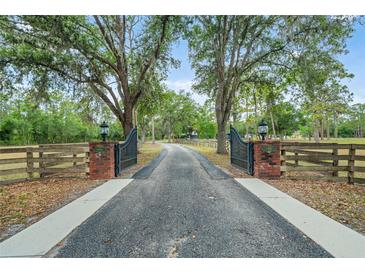 Long private driveway with gate and beautiful mature shade trees leading to the home at 140 Cowpen Ln, Sarasota, FL 34240