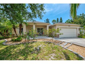 Beautiful single-Gathering home with well-manicured landscaping, a two-car garage, and a cozy front porch at 1715 Fossil Dr, Englewood, FL 34223