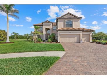 Stately two-story home featuring a three-car garage, tile roof and paved driveway with lush landscaping at 20831 Valprato Ct, Venice, FL 34293