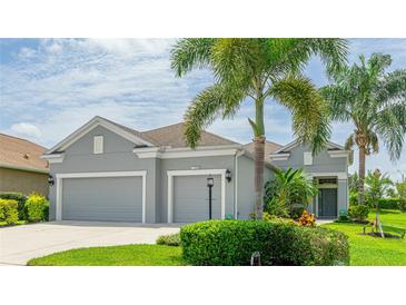 Charming home featuring a well-manicured lawn, mature landscaping and a three-car garage at 2240 Crystal Lake Trl, Bradenton, FL 34211