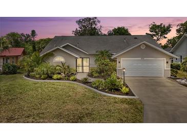 Charming single-story home with a well-manicured lawn, a two car garage and lush tropical landscaping at 5750 Carriage Dr, Sarasota, FL 34243