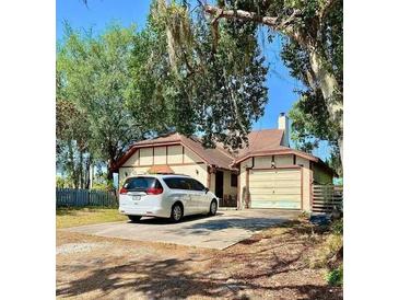 Charming single-story home with a well-maintained lawn and a private driveway with a white van at 6265 Viola Ln, New Port Richey, FL 34653