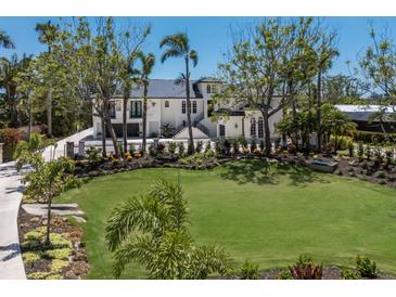 Stunning home with a lush green lawn, mature trees and manicured landscaping creating a picturesque setting at 705 89Th Nw Ct, Bradenton, FL 34209