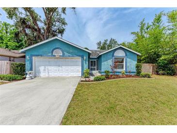 Charming blue home with a well-manicured lawn and a white two-car garage at 7810 34Th E Ct, Sarasota, FL 34243