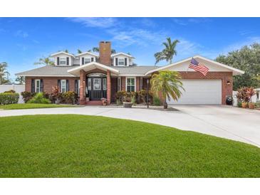 Charming brick home featuring a manicured lawn, American flag and attached two-car garage at 1904 Nw 79Th St, Bradenton, FL 34209
