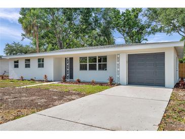 Charming single-story home featuring a gray garage door and fresh landscaping at 3193 Bellevue St, Sarasota, FL 34237