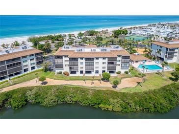 Aerial view of beachfront condo with pool and tennis courts, offering luxury coastal living at 3540 Gulf Of Mexico Dr # 303, Longboat Key, FL 34228