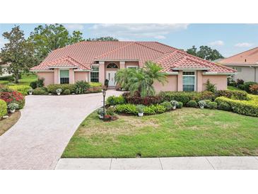 Beautiful single-story home with a terracotta roof, manicured landscaping, and a circular driveway at 431 Fieldstone Dr, Venice, FL 34292