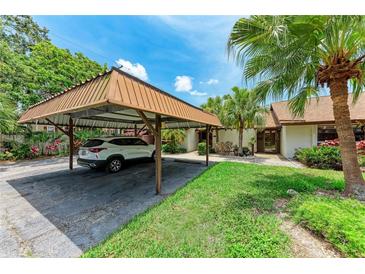 Home featuring a covered carport and tropical landscaping, offering shade and curb appeal at 4644 Red Maple Rd # 1303, Bradenton, FL 34210