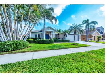 Charming single-story home with lush landscaping, palm trees, and a well-manicured lawn at 5320 Layton Dr, Venice, FL 34293
