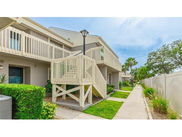 Charming condo exterior with well-maintained landscaping and stairs to the second level under a sunny sky at 5964 7Th W Ave # 5964, Bradenton, FL 34209