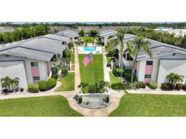 Aerial view of condominiums with well-kept grounds, community pool, landscaping and central flagpole at 2507 Beneva Rd # 2, Sarasota, FL 34232
