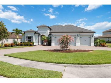 Charming single-story home featuring a three-car garage, lush landscaping, and a well-manicured front lawn at 308 Chantilly Trl, Bradenton, FL 34212